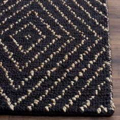 a black and white rug on top of a wooden floor