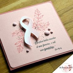 a pink card with a white ribbon on it