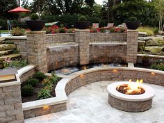 an outdoor fire pit surrounded by stone walls