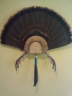 an old fan hanging on the wall with two claws sticking out of it's side