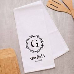 two personalized kitchen towels with wooden utensils