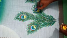 someone is painting peacock feathers on a table cloth