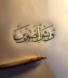 an arabic calligraphy written in green ink on a white paper with a gold pen