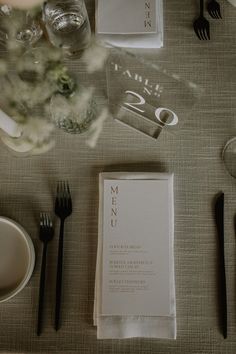 the table is set with silverware and menus