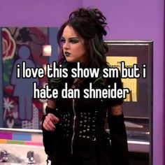 a woman with green hair and black makeup is standing in front of a mirror that says i love this show smm but i hate dan sheder