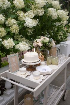 a table topped with a cake next to white flowers