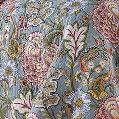 the comforter is made up with colorful flowers on it