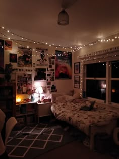 a bedroom with lights strung from the ceiling and pictures on the wall above the bed