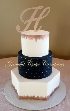 a three tiered cake with the letter h on top