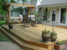 a wooden deck surrounded by potted plants