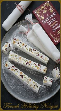 four pieces of white chocolate sitting on top of a glass plate next to a book