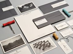 an assortment of stationary items displayed on a gray surface with magnets and postcards