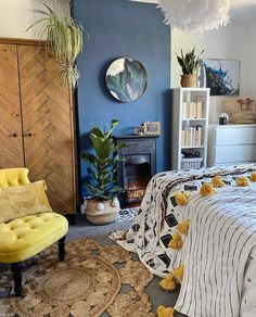 a bedroom with blue walls and rugs on the floor next to a yellow chair