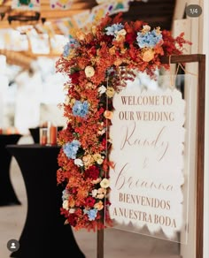 a welcome sign is decorated with flowers and leaves for an outdoor wedding reception at the resort