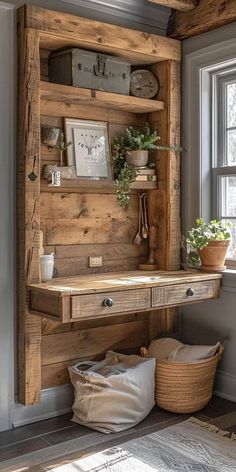 a wooden desk sitting under a window next to a basket filled with plants and potted plants