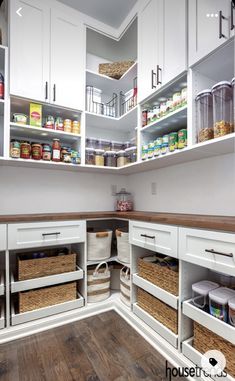 an organized pantry with white cabinets and baskets