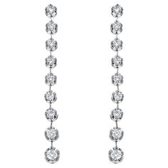 These elegant diamond dangle drop earrings feature a cascade of round brilliant-cut diamonds, totaling approximately 0.95 carats. Each diamond is meticulously matched for size and set in a timeless bezel setting that enhances their individual brilliance while creating a seamless line of sparkle. The diamonds graduate in size, with the largest stones at the base, drawing the eye downward with a graceful taper. The brilliance of the diamonds is heightened by their settings, crafted from lustrous m Long Diamond Earrings, Base Drawing, Temple Square, Circle Diamond, Drop Earring, Round Brilliant Cut Diamond, Long Earrings, Bezel Setting, White Gold Diamonds