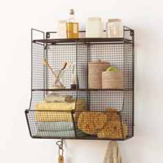 a metal shelf with towels, soaps and other items on it in a bathroom