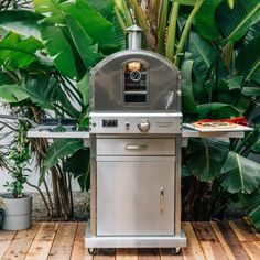 an outdoor bbq grill on a wooden deck with potted plants in the background