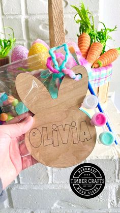 a person holding up a wooden sign that says ollivia