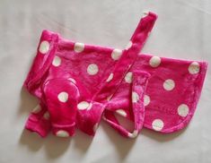 two pink and white polka dot pajamas laying on top of each other