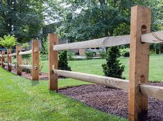 a wooden fence in the middle of a grassy area