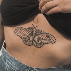 a woman's stomach with a moth tattoo on it