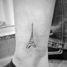 a small black and white photo of the eiffel tower tattoo on the ankle