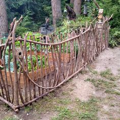 a wooden fence made out of sticks in the woods