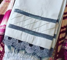 three pieces of white and blue cloth on a bed