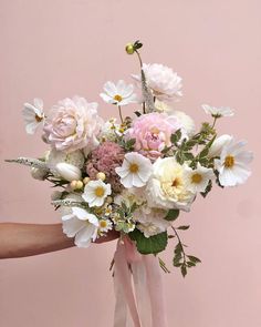 a woman holding a bouquet of flowers in her hand