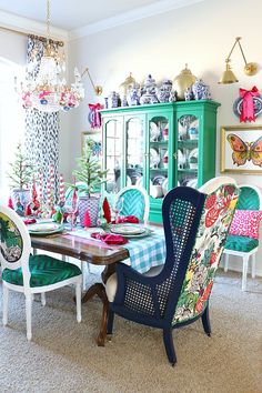 the dining room table is decorated with bright colored chairs and colorful china cabinet in the background