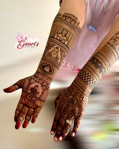 a woman's hands with henna tattoos on her arm and hand, all decorated in intricate designs