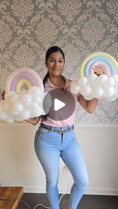 a woman is holding balloons in her hands