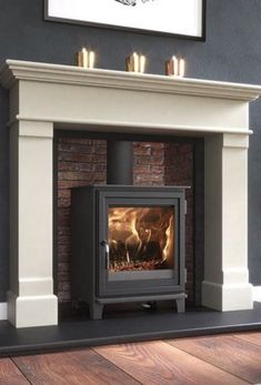 a wood burning stove in a living room next to a rug and painting on the wall