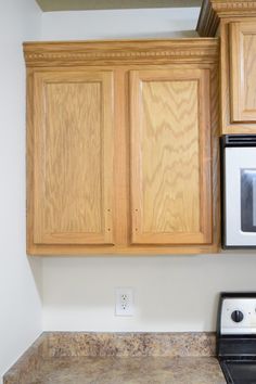 a stove top oven sitting inside of a kitchen next to wooden cupboards and counter tops