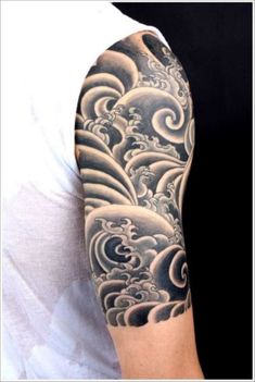 a man's arm with waves and clouds tattoo on his sleeve, in black and white