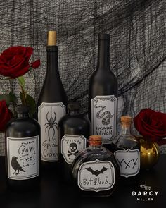 bottles with labels on them sitting next to red roses