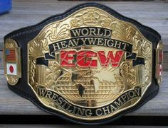 a gold and black wrestling belt sitting on top of a wooden table