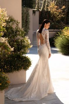 a woman in a wedding dress standing outside