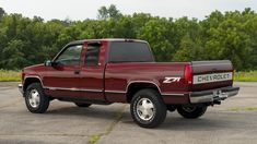 a red pick up truck parked in a parking lot