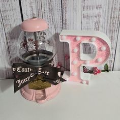 a pink gumper machine with the letter p next to it on a white table