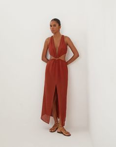 From the ViX + Bianca Brandolini Capsule Collection, the Dasha Detail Long Dress embodies bohemian chic with a refined touch. This stunning maxi dress is designed to flatter every figure, featuring a curve-enhancing silhouette, bold gold accent, and gracefully draping fabric at the waist. Made from organic fibers, it showcases the meticulous craftsmanship of our Rio de Janeiro artisans, while capturing Bianca's signature blend of sophistication and carefree spirit. Embrace a piece that celebrate Unlined Bohemian Maxi Dress, Chic Brown Floor-length Dresses, Unlined Maxi Beachwear Dress, Elegant Brown Beach Maxi Dress, Chic Brown Midi Dress For Beach, Bianca Brandolini, Skirt Shapewear, Vix Swimwear, Draping Fabric