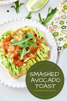 an avocado toast on a plate topped with tomatoes and lettuce