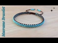 two blue and black braided bracelets sitting on top of a wooden table