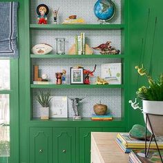 a green bookcase with books and pictures on it