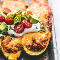 an omelet with tomatoes, avocado and sour cream on top is sitting on a baking sheet