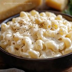 a bowl filled with macaroni and cheese on top of a wooden table