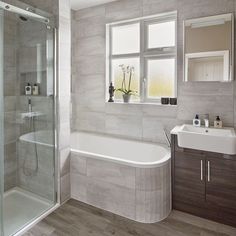 a bathroom with a sink, toilet and bathtub next to a window in it