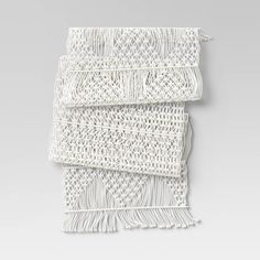 three pieces of white woven material with fringes